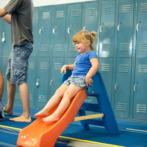 little girl sliding into a foam pit